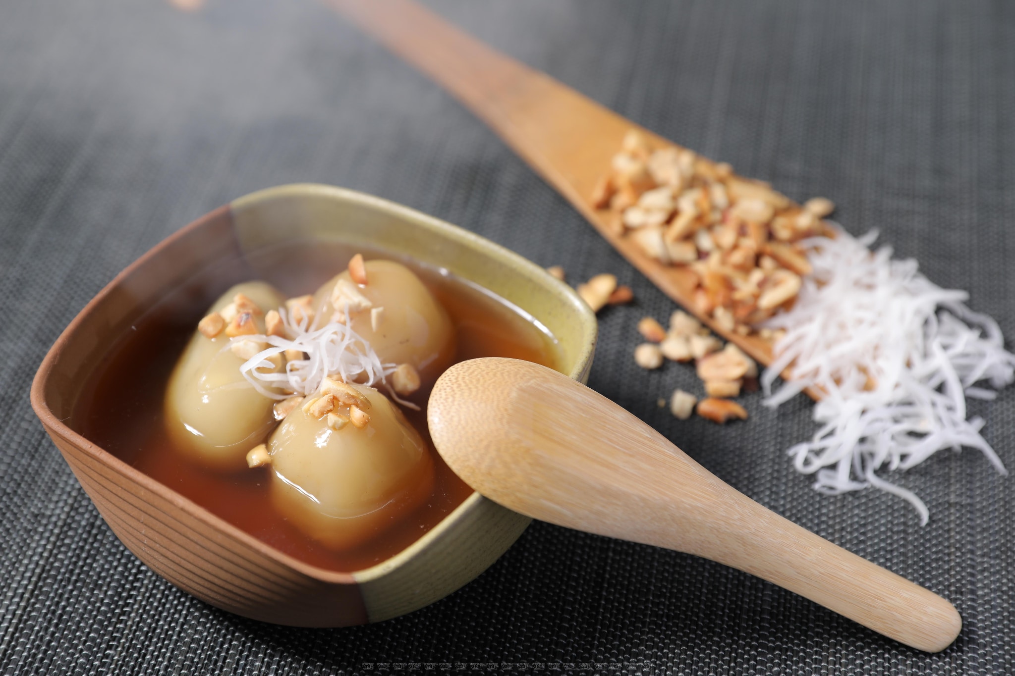 Translucent white rice balls floating gracefully in golden ginger syrup